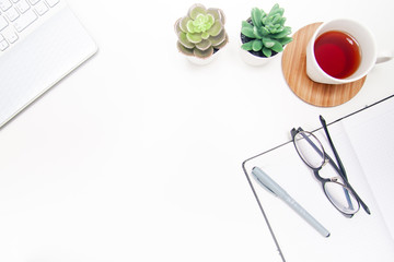 Workspace with glasses laptop, notebook, sketchbook, succulent, cup of tea on white background. Flat lay, top view office table desk. Freelancer working place. copyspace