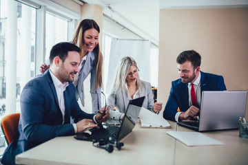 Creative business people working on business project in office using laptop.