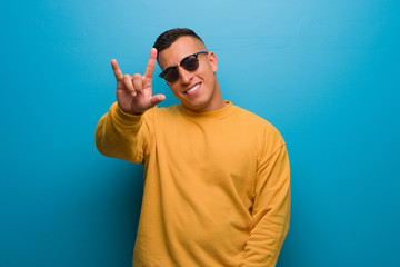 Young colombian man doing a rock gesture