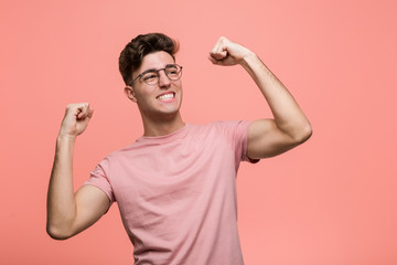 Young cool caucasian man raising fist after a victory, winner concept.