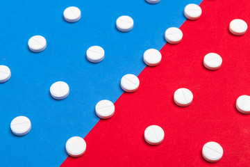 White medical pills on a two color red and blue background