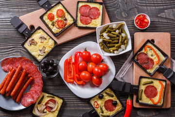 young woman is preparing a traditional Swiss cheese raclette