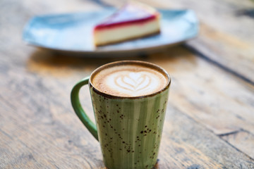 Latte coffee and cheesecake on a table
