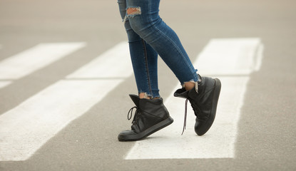 close up of woman legs walking on crosswalk. 