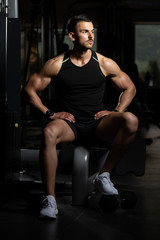 Obraz na płótnie Canvas Man Rests In Gym After Having A Workout