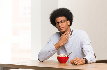 Fototapeta na wymiar Young black man having a breakfast coughing, sick due a virus or infection