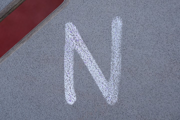 A simple letter N painted on a wall.