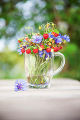 Bouquet from wild strawberry and flowers. Healthy natural food. Ecological clean products