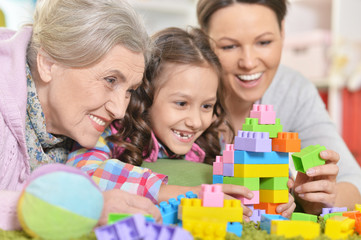 Happy smiling family playing with colorful plastic blocks