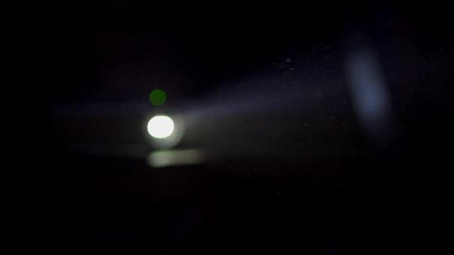 video projector lens spotlight 4K projecting in a dark studio in tight shot with blur Lentille spot vid&eacute;o projecteur 4K