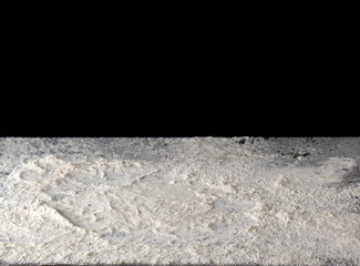 scattered white wheat flour on the surface, black background
