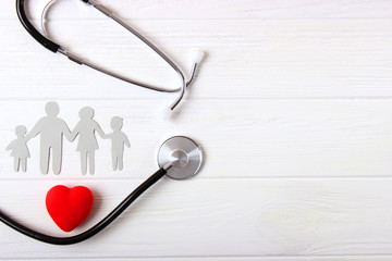 stethoscope and heart on a colored background top view. Family medicine