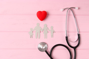 stethoscope and heart on a colored background top view. Family medicine