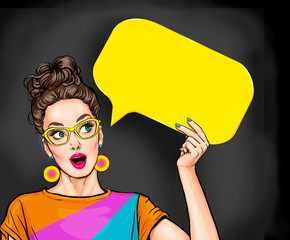 Amazed young sexy woman with open mouth looking up on empty yellow bubble.Pop Art girl is thought and holding message cloud. © lucky1984