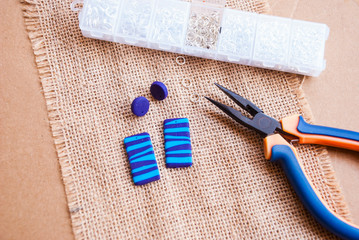 Assembly of handmade abstract earrings. Hobby jewelry background.