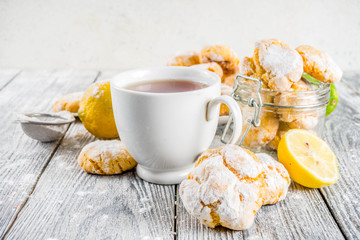 Lemon Crinkle Cookies, homemade sweet and sour baking with tea cup, white wooden background copy space