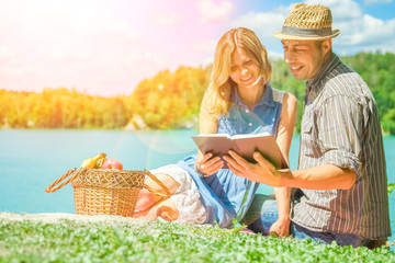 happy couple having picnic by the sea in nature