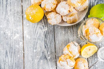 Lemon Crinkle Cookies, homemade sweet and sour baking with tea cup, white wooden background copy space