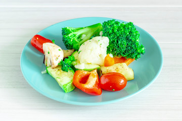 Fresh vegetables in blue plate on white background. Healthy food.