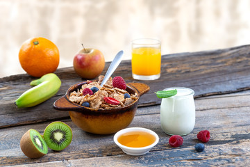 Healthy breakfast with natural yogurt, muesli and berries on white wooden background, closeup, horizontal