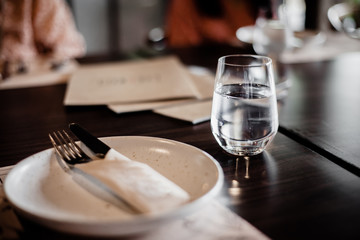 A glass of cold mineral water on the dining table in the restaurant .