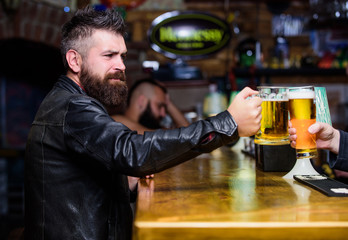 Cheers concept. Glasses with fresh lager draft beer with foam. Men hipster hold mugs filled with cold tasty beer in bar. Friday leisure tradition. Beer mugs at bar counter defocused background