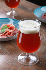 Close up view on cold amber beer in a glass with snack at bar on table. Bar image cocnept with copy space for logo or brand. Refreshing alcoholic drinks. Tasty restaurant snacks