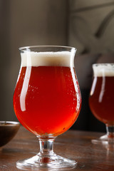 Close up view on cold amber beer in a glass with snack at bar on table. Bar image cocnept with copy space for logo or brand. Refreshing alcoholic drinks. Tasty restaurant snacks