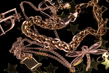 Abstract gold chain, braclet and jewerly on a dark background