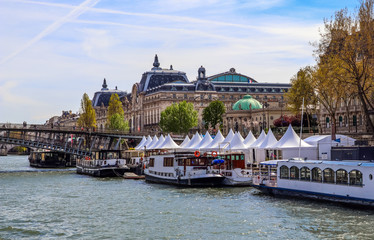Fototapeta premium Pedestrian bridge (Passerelle Léopold-Sédar-Senghor) over Seine river, boats and historic buildings of Paris France
