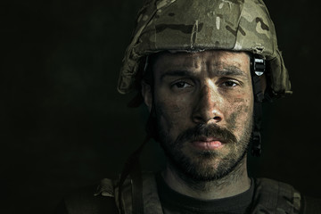 No feels and emotions. Close up portrait of young male soldier. Man in military uniform on the war. Depressed and having problems with mental health and emotions, PTSD, rehabilitation.