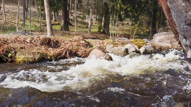 Panning shot of a stream of water building up white foam when the water flowing at high speed. Filmed in slow motion at 1080p. Camera moves from right to left.