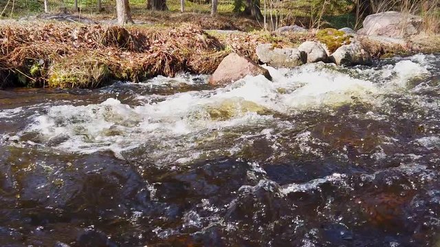 Panning shot of a stream of water building up white foam when the water flowing at high speed. Filmed in slow motion at 1080p. Camera moves from left to right.