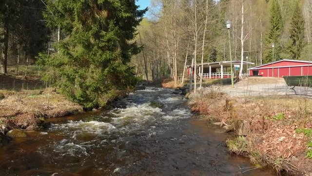 Drone footage flying really close to a fast flowing stream of white foamed water. Filmed in realtime at 4K.