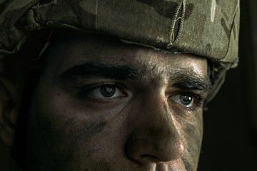 What have I do with my life. Close up portrait of young male soldier. Man in military uniform on the war. Depressed and having problems with mental health and emotions, PTSD, rehabilitation.