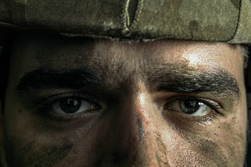 Looking deeper for a reason. Close up portrait of young male soldier. Man in military uniform on the war. Depressed and having problems with mental health and emotions, PTSD, rehabilitation.
