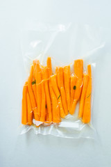 Vacuum sealed vegetables , carrots, on a gray background top view, ready o be cooked with sous vide rooner