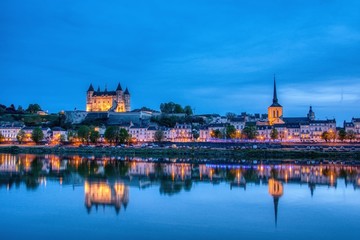 Panorama of Saumur at night with the medieval castle and the Saint-Pierre church, France.