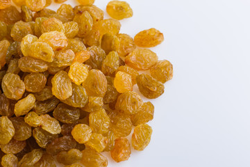 golden raisins on a white acrylic background
