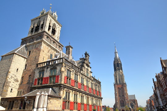 The external facade of the Town Hall (rebuilt in 1629) on the left and the clock tower of Nieuwe Kerk on the right, Delft, Netherlands