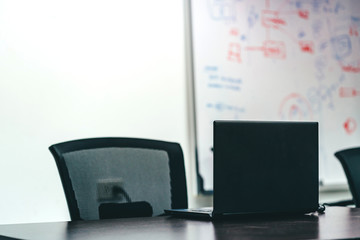Laptop on black table for business presentation in the meeting room.