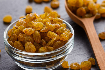 golden raisins on a dark stone background