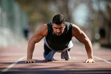 Fototapeta premium Fitness man doing push ups outdoor