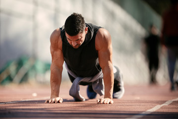 Fototapeta premium Fitness man doing push ups outdoor. Athlete training.