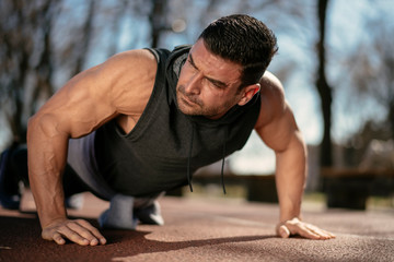 Obraz premium Fitness man doing push ups outdoor. Athlete training.