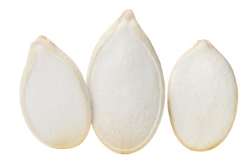 Three pumpkin seeds closeup isolated on white. Macro. Side view.
