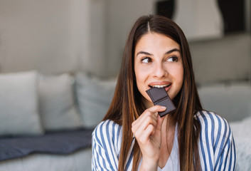 Young woman eating dark chocolate. 