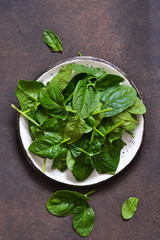 Fresh, young green spinach on a concrete background. View from above.