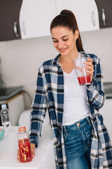 Young woman drinking smoothie at home