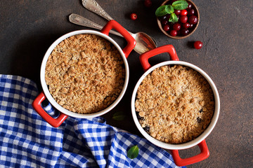 Crumble with cranberries and other berries, nuts on the kitchen table. View from above.